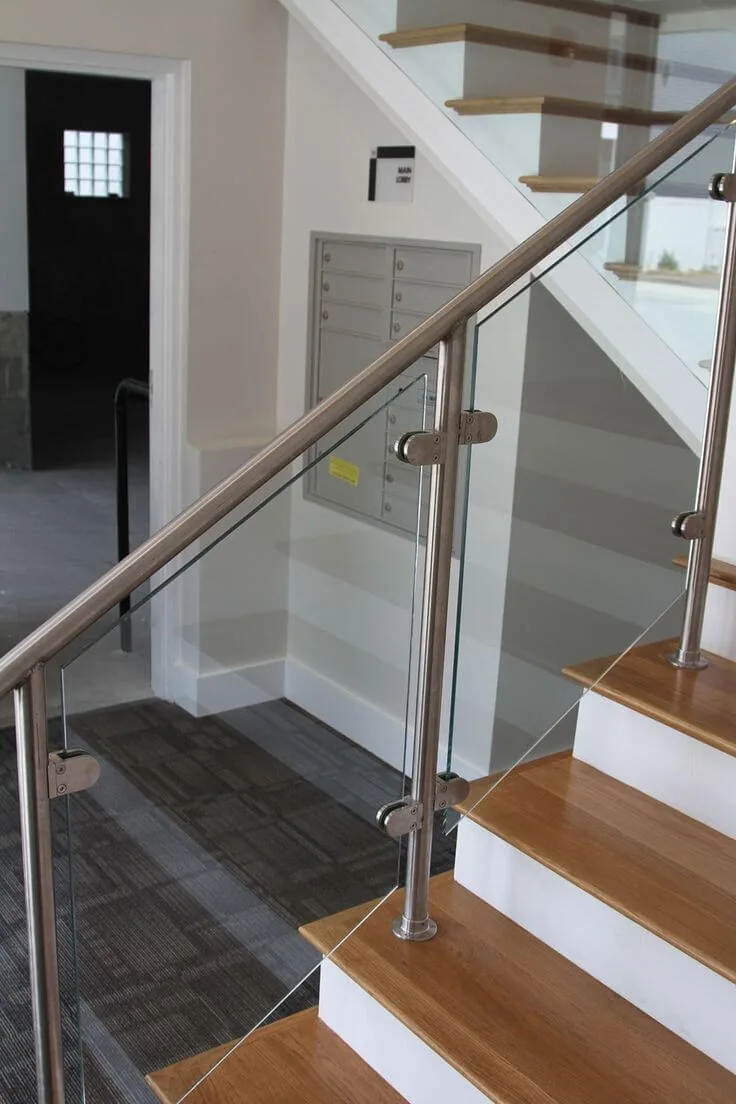 Glass stair railing with a stainless handrail over timber treads