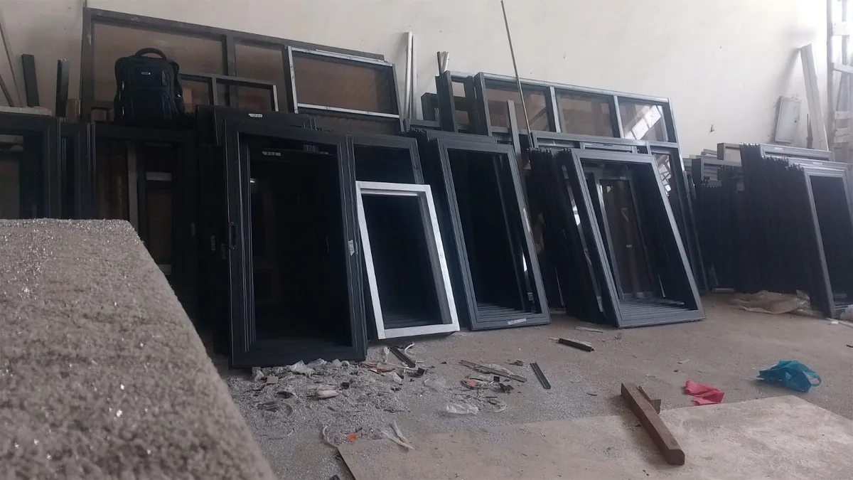 Fabricated window and door frames laid out across the EGZ workshop floor