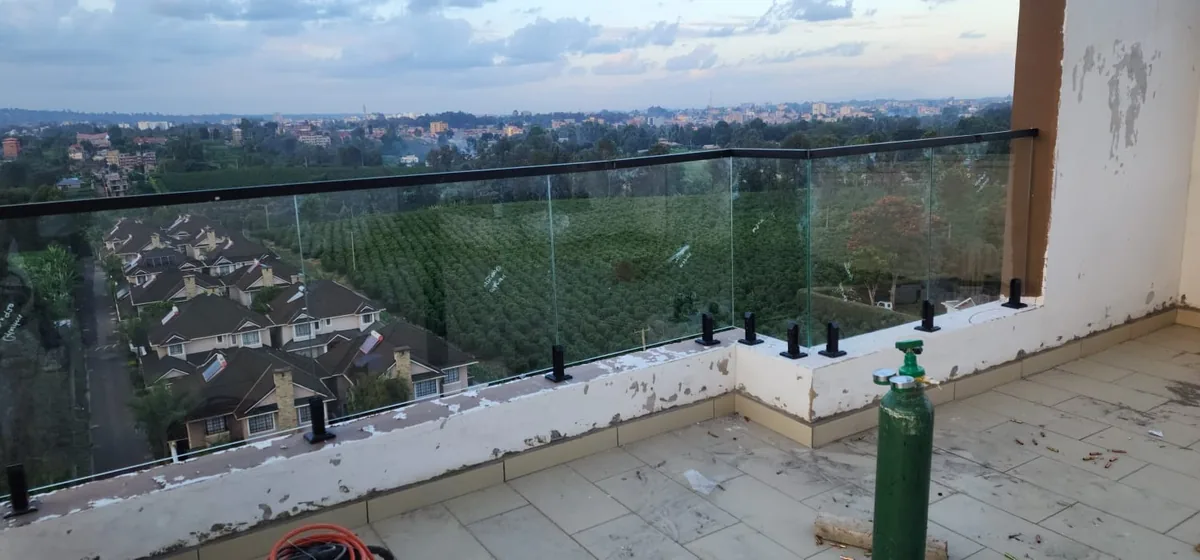 Frameless glass balustrade enclosing a balcony with a valley view