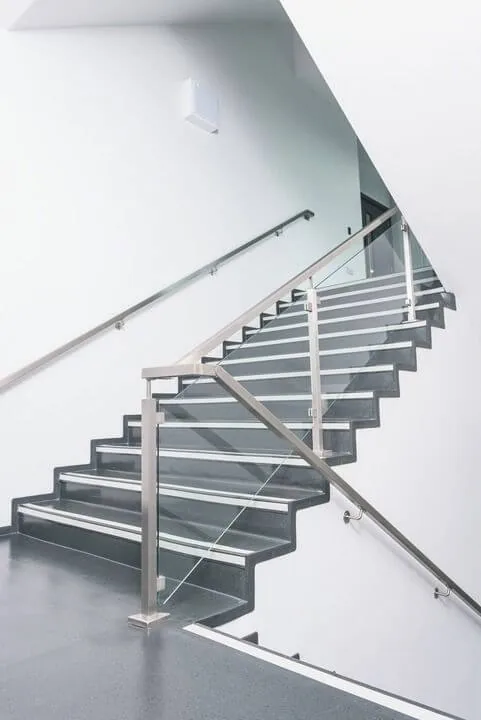Stainless steel stair railing with vertical infill over a floating flight