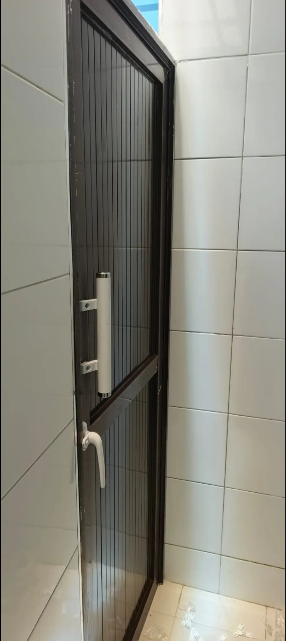 OPEC aluminium toilet door fitted to a tiled washroom opening