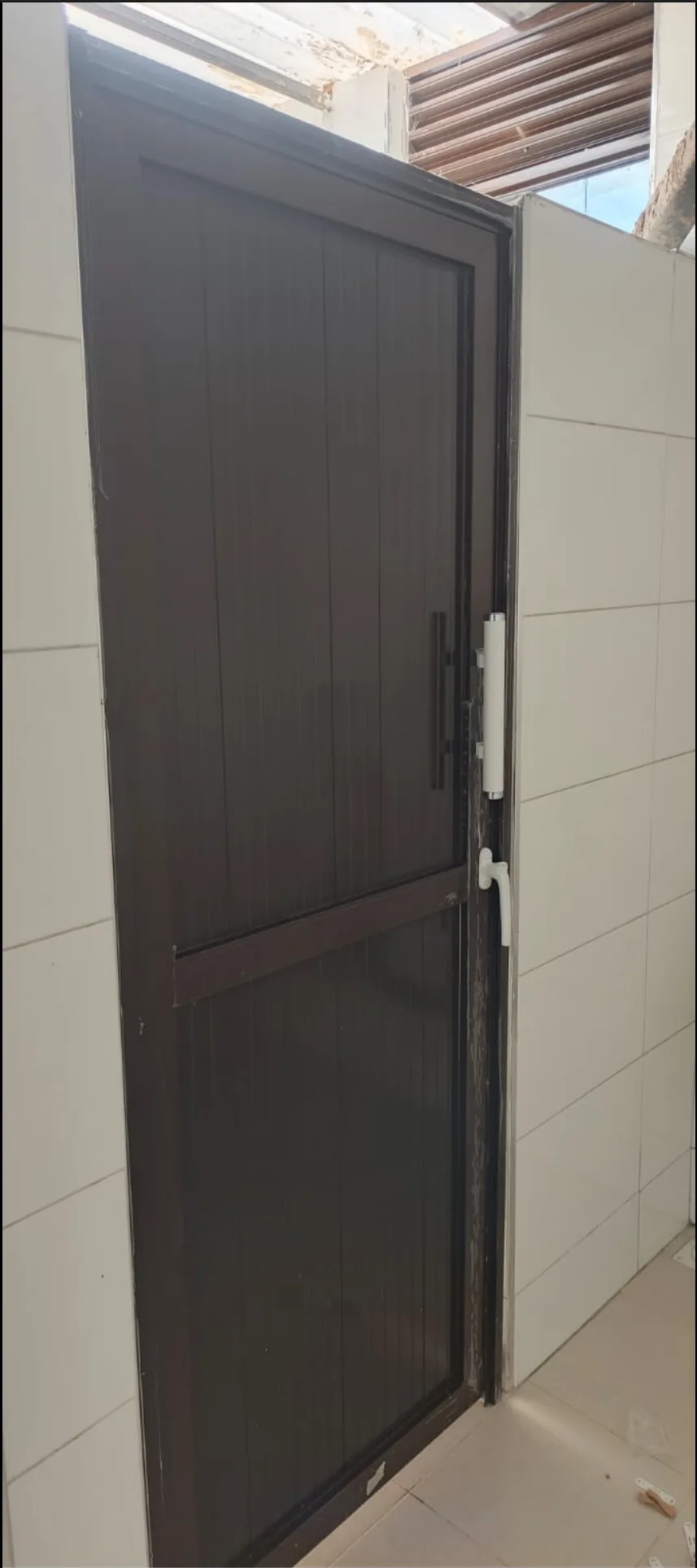 OPEC aluminium toilet door fitted to a tiled washroom opening